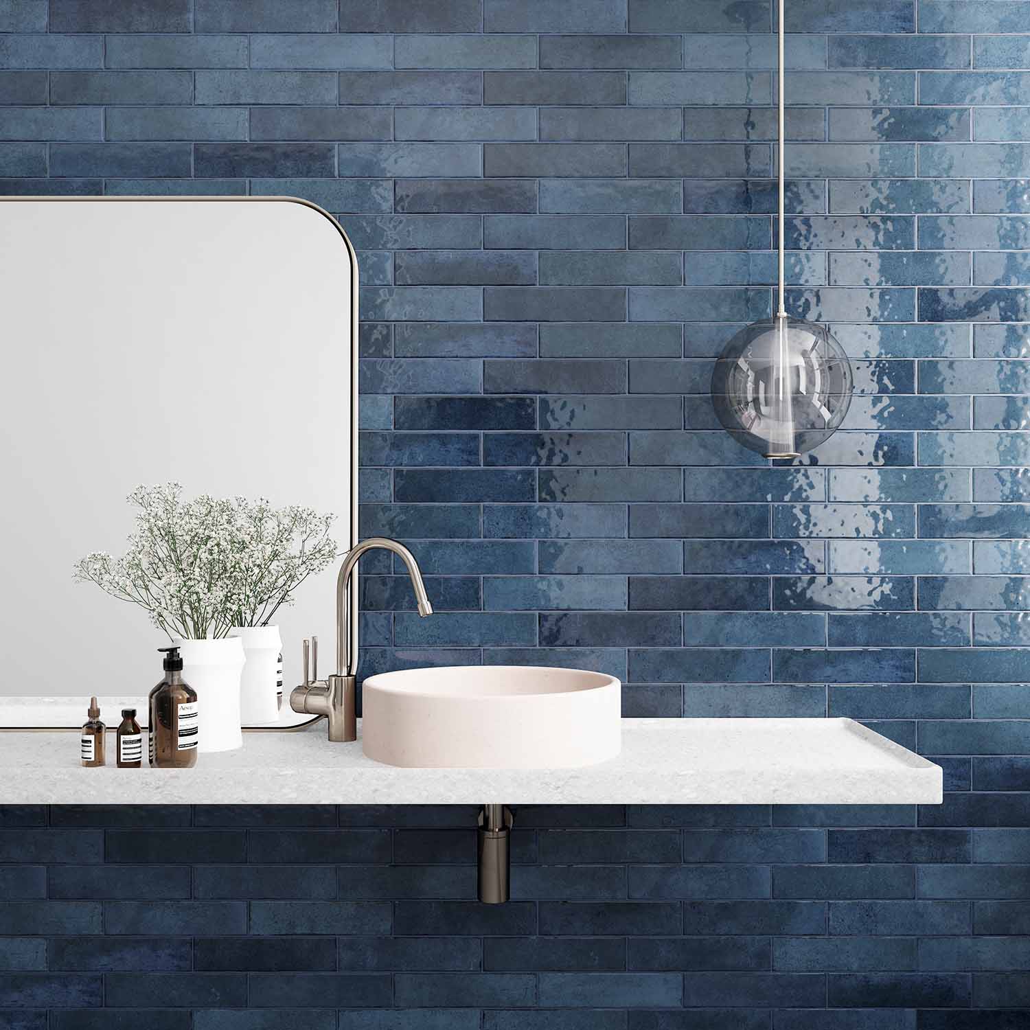 a white sink sitting under a mirror next to a blue tiled wall.